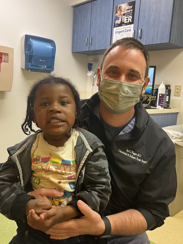 A girl, standing with her doctor, who has been treated for cleft lip.